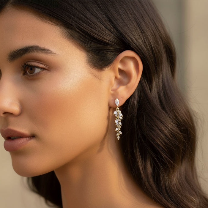 Close-up of a woman wearing a leaf-shaped earring with a blurred background