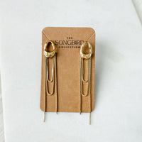 Gold chain earrings on a 'The Songbird Collection' branded card against a white background