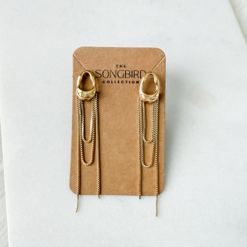 Gold chain earrings on a 'The Songbird Collection' branded card against a white background