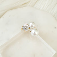 Pearl and diamond earring on a white surface