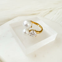 Gold ring with a pearl and clear gemstone on a white surface Arianne Pearl Ring - The Songbird Collection