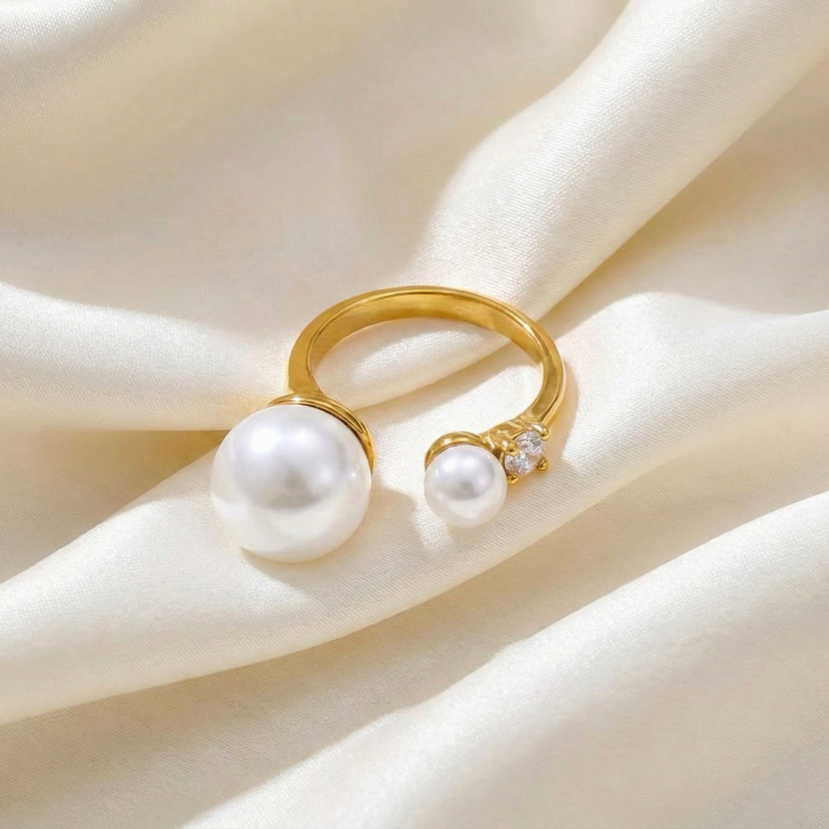 Gold ring with pearls on a soft beige fabric background Arista Open Pearl Ring - stainless steel - The Songbird Collection