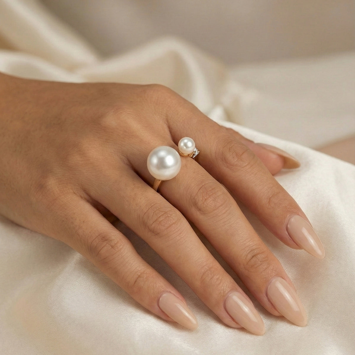Hand wearing a pearl ring on a soft fabric background - Arista Open Pearl Ring - stainless steel - The Songbird Collection