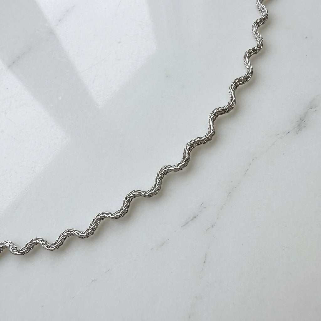 Silver wavy chain on a marble surface - Aura_Ripple_Chain_Bracelet_-_The_Songbird_Collection