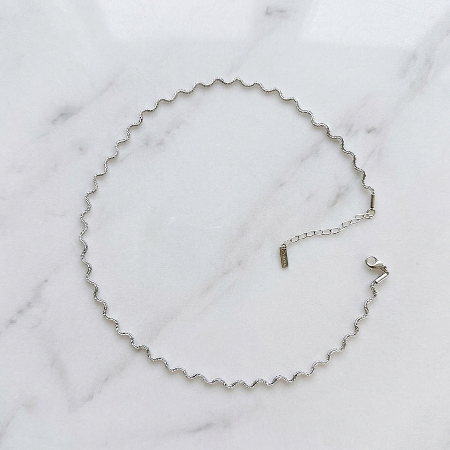 stainless steel silver wavy chain necklace a marble surface - Aura_Ripple_Chain_Necklace_-_The_Songbird_Collection