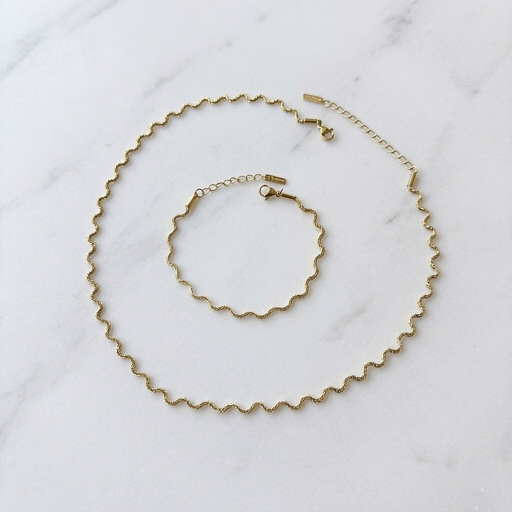 Gold necklace and bracelet set on a marble surface - Aura Ripple  WAVY Chain Necklace and Bracelet - The Songbird Collection
