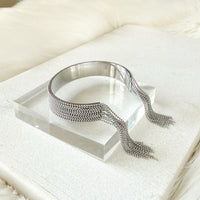 Silver beaded cuff on a clear stand with a white background