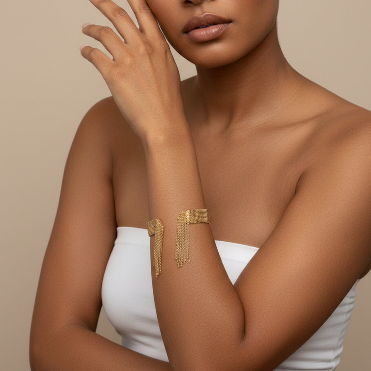 Woman wearing a gold arm band against a beige background - Beaded_Fringe_Statement_Bracelet_Cuff_-_The_Songbird_Collection