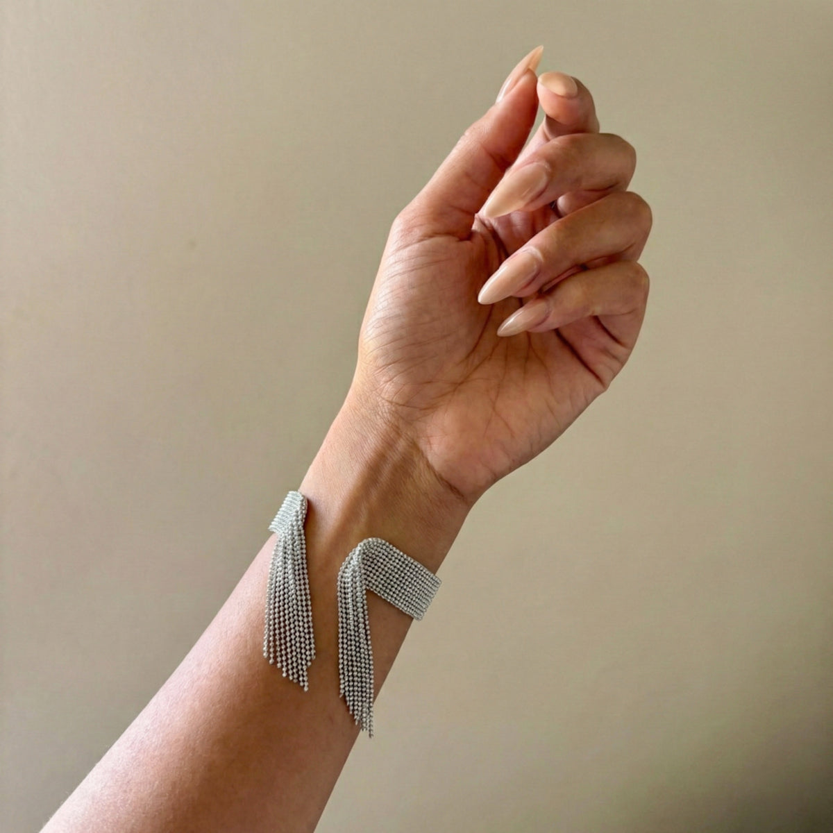 Hand wearing a delicate bracelet against a neutral background - Beaded_Fringe_Statement_Bracelet_Cuff_-_The_Songbird_Collection