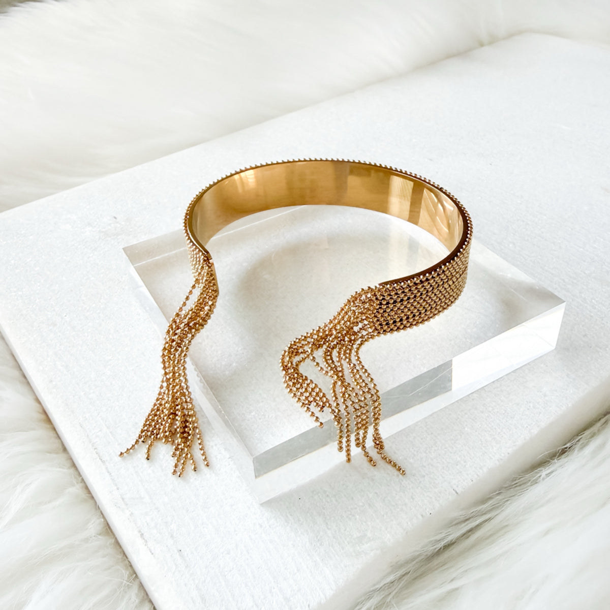 Gold beaded cuff on a white surface