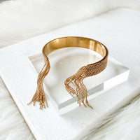 Gold beaded cuff on a white surface