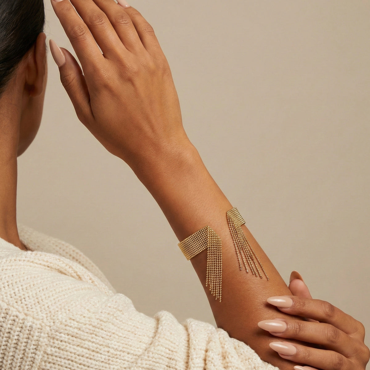 Woman wearing a gold arm band with fringe design on a beige background Beaded_Fringe_Statement_Bracelet_Cuff_-_The_Songbird_Collection
