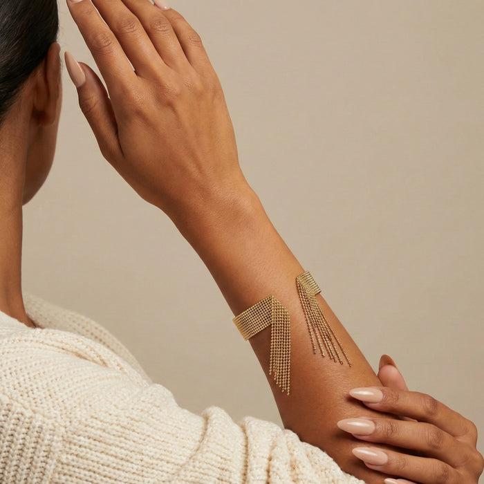 Woman wearing a gold arm band with fringe design on a beige background Beaded_Fringe_Statement_Bracelet_Cuff_-_The_Songbird_Collection