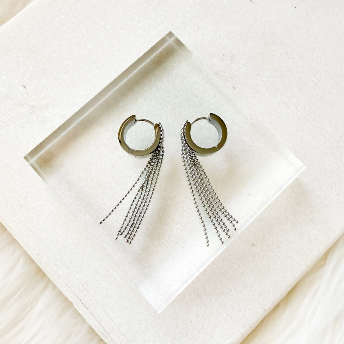 Hoop earrings with chain tassels on a white napkin