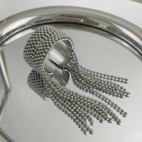 Silver beaded ring on a reflective surface