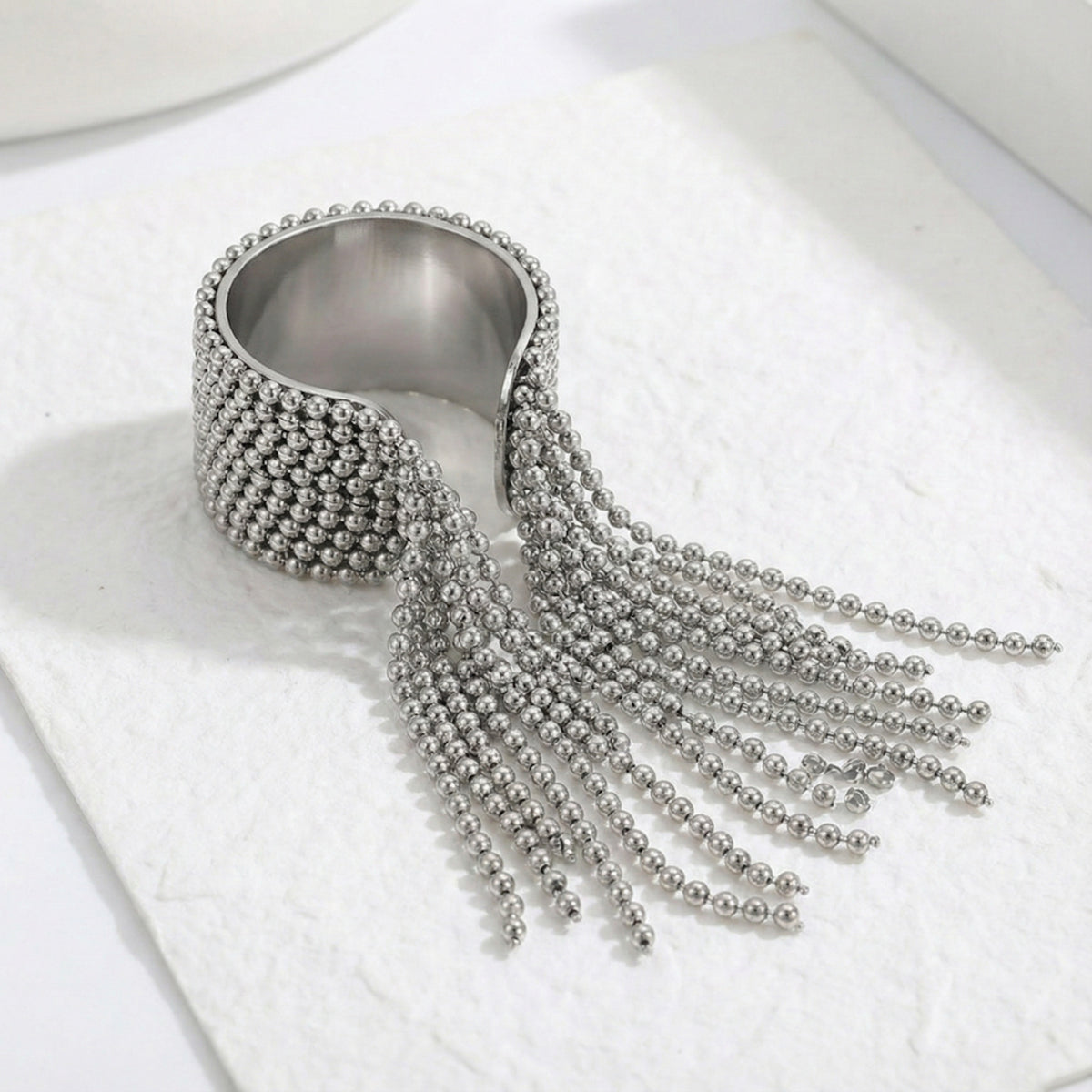 Silver beaded fringe ring on a white background