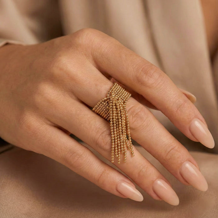 Gold beaded ring on a hand with a neutral background  Beaded Fringe Statement Ring - The Songbird Collection