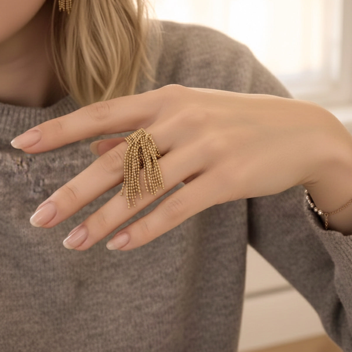 Close-up of a hand wearing a gold fringe ring with a blurred background Beaded Fringe Statement Ring - The Songbird Collection