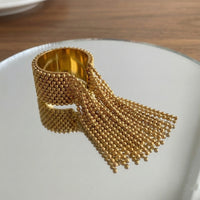 Gold beaded ring a white plate with a wooden surface in the background