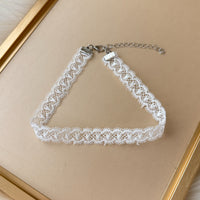 White lace choker necklace on a beige background
