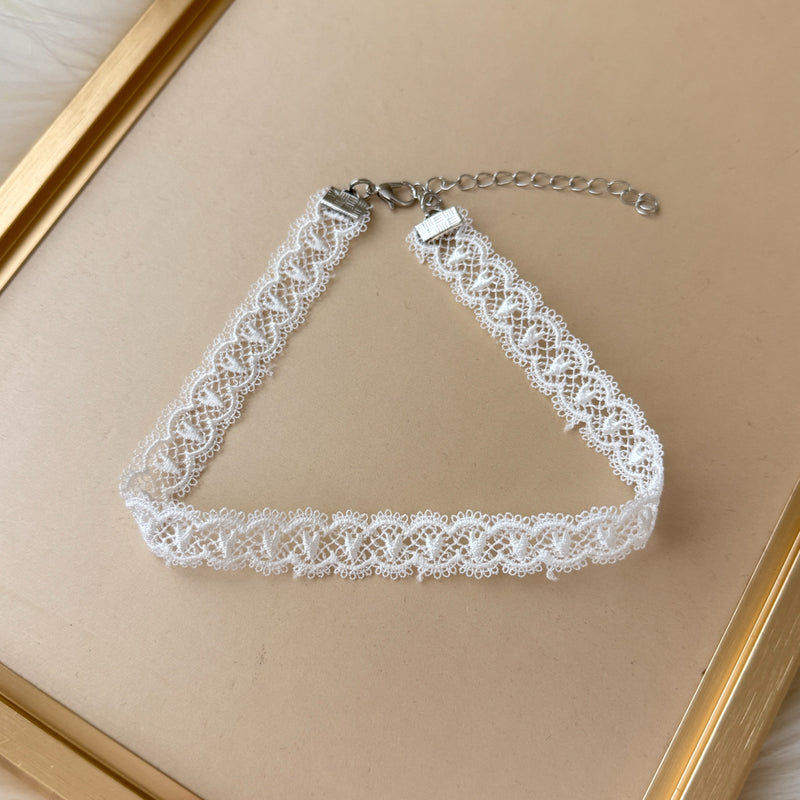 White lace choker necklace on a beige background