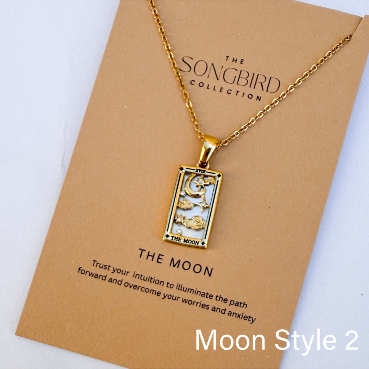Gold necklace with 'The Moon' pendant on a 'Songbird Collection' card