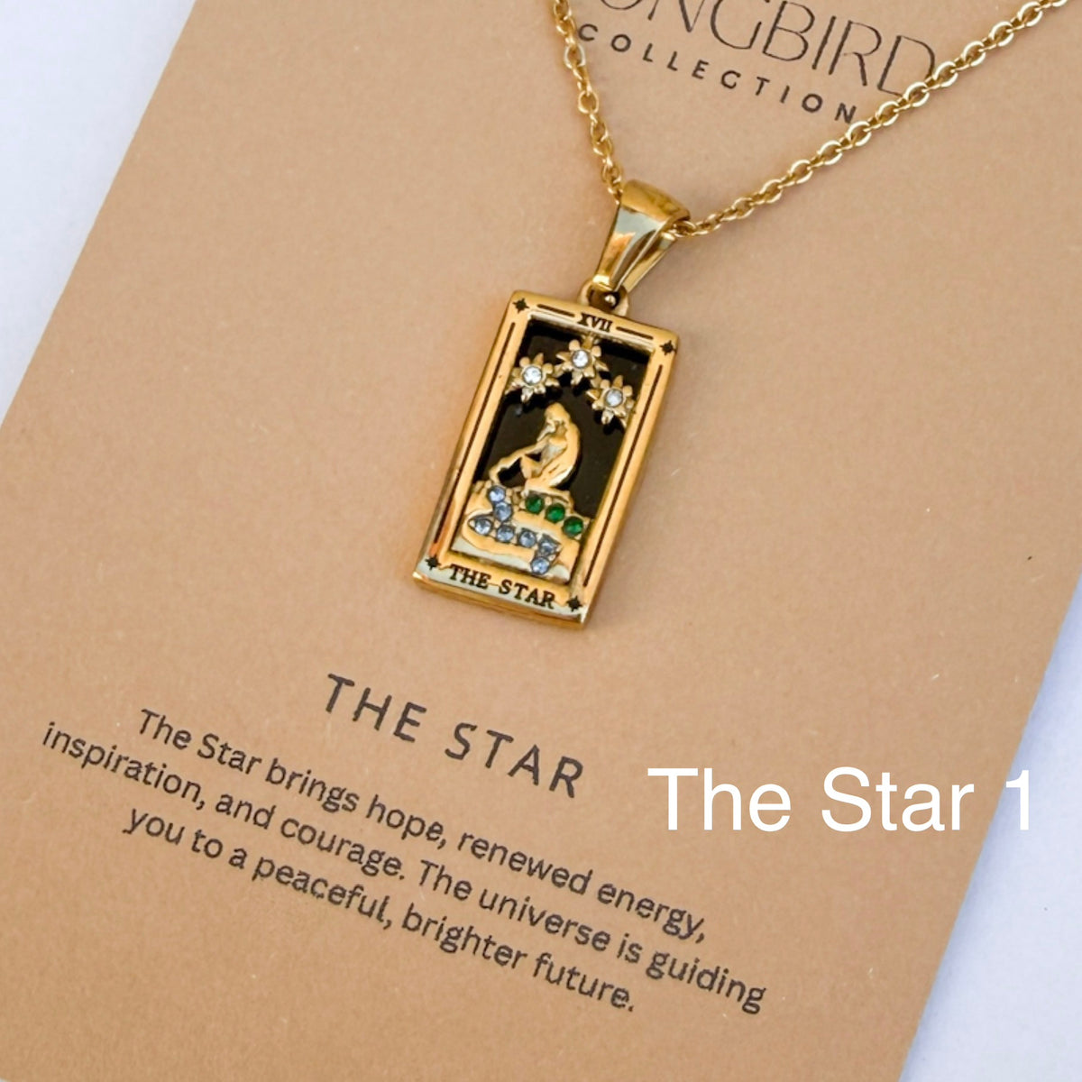 Gold pendant necklace with 'The Star' design on a card from the SONGBIRD Collection.