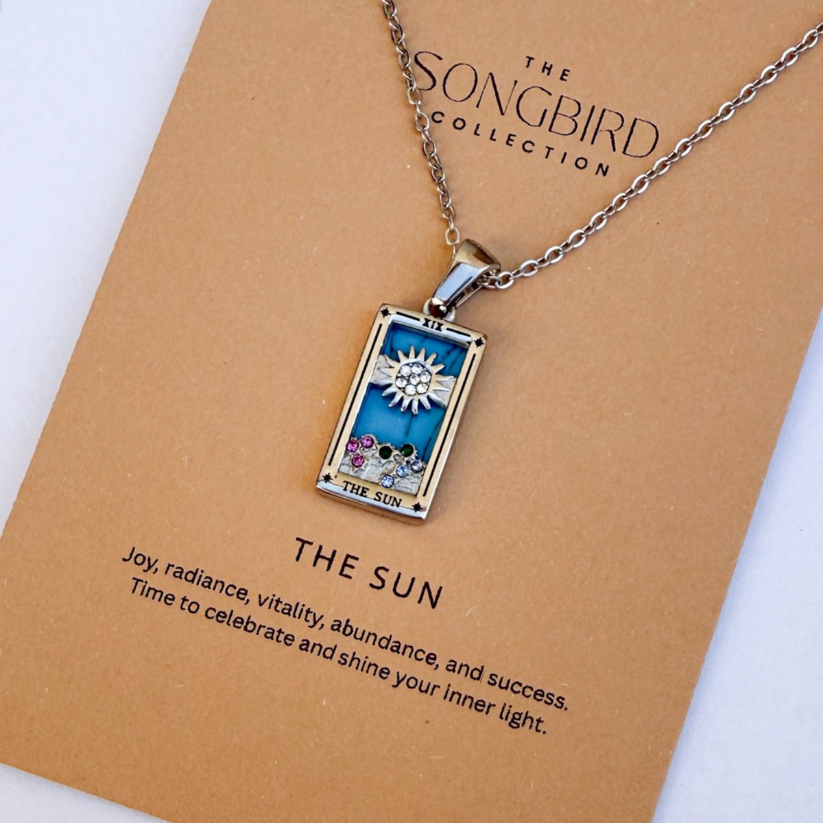 Necklace with 'The Sun' pendant from The Songbird Collection on a brown card.