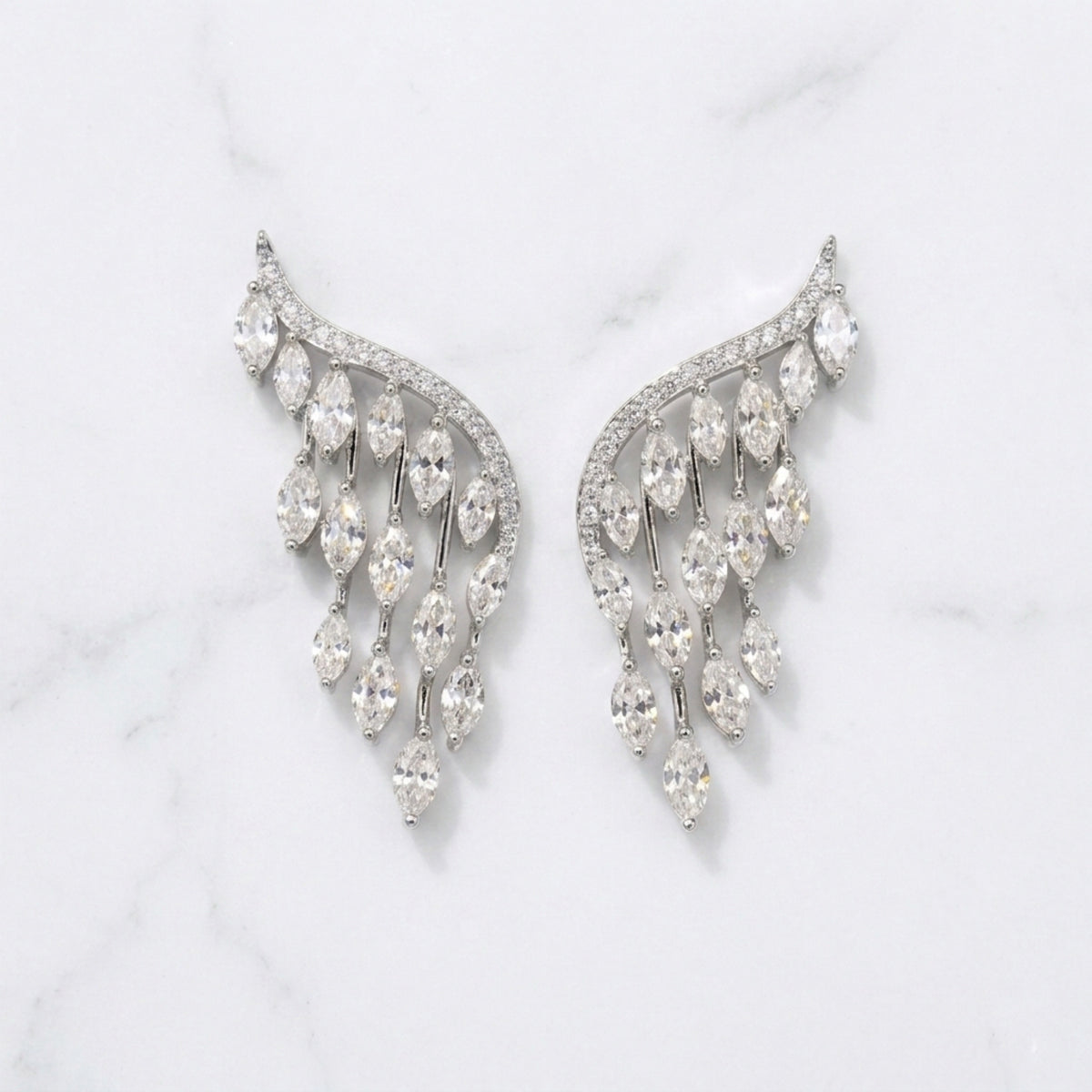 Pair of silver earrings with clear gemstones on a light gray background  Chandelier_Earrings_-_The_Songbird_Collection