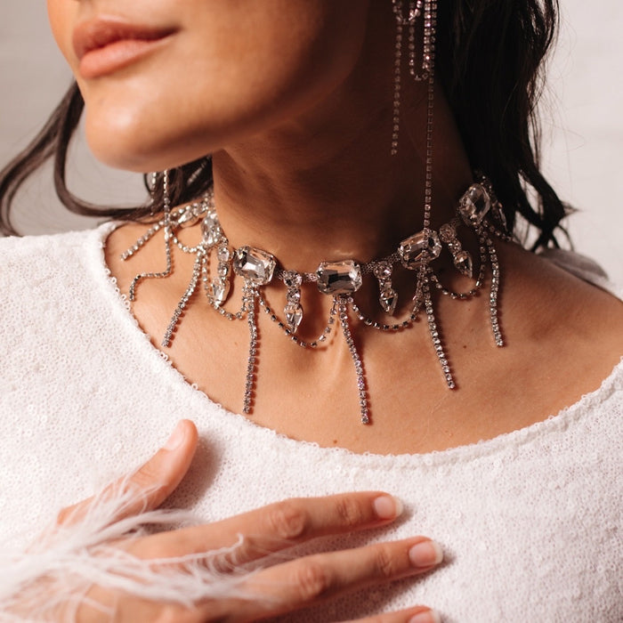 A close-up of a Chunky Geo Rhinestone Drop Necklace with a detailed chain design and rhinestone embellishments, worn by a person.