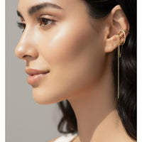Close-up of a woman wearing gold earrings with a neutral background