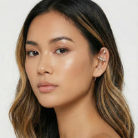 Close-up of a woman with long, wavy hair wearing an earring against a white background  Crystal_Bliss_Ear_Hook_Ear_Cuff-Earrings-The_Songbird_Collection