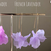 Purple flower earrings on a stand with 'French Lavender' text on a gray background