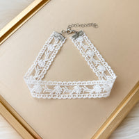 White lace choker necklace on a beige background