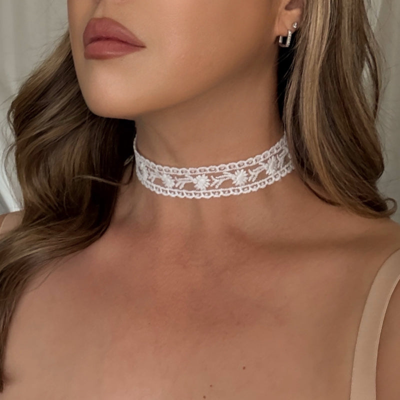 Close-up of a woman wearing a delicate lace choker necklace.