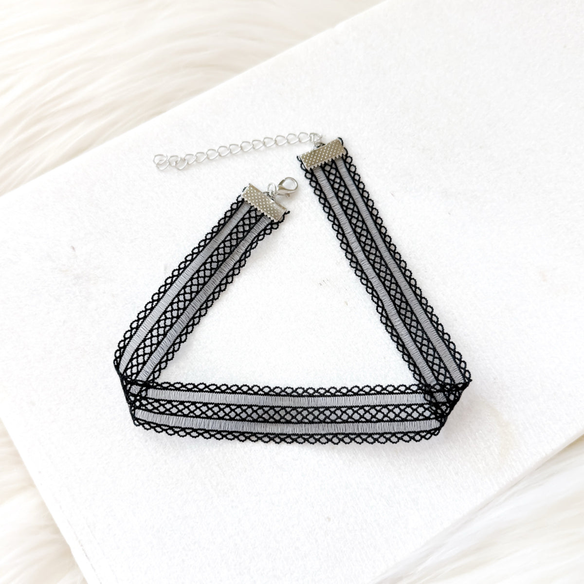 Black mesh lace choker necklace on a white surface