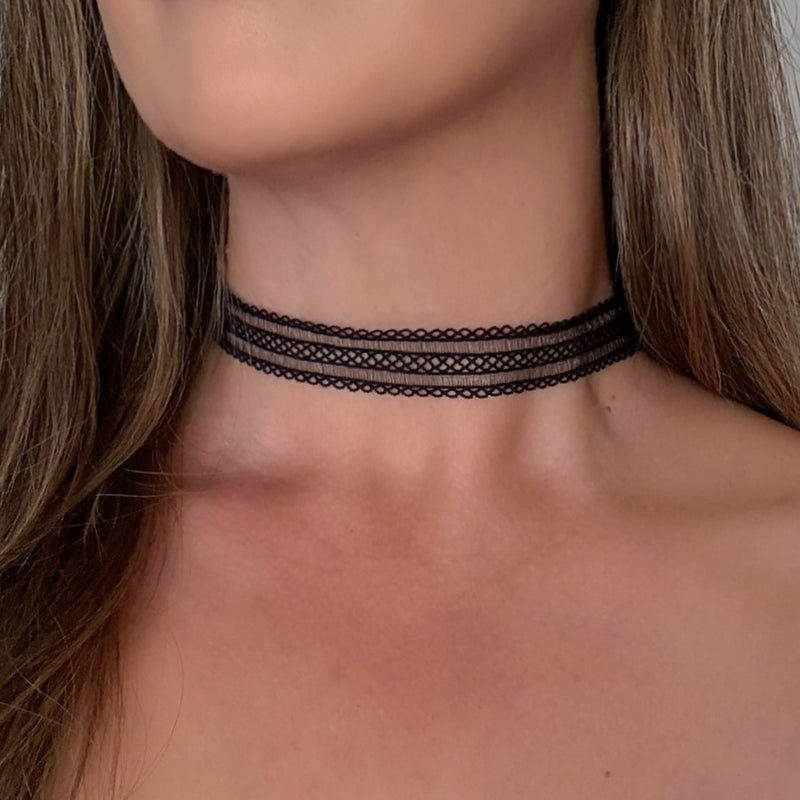 Black lace choker necklace worn by a person with long hair.