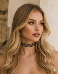 Woman with long blonde hair wearing a choker necklace against a neutral background