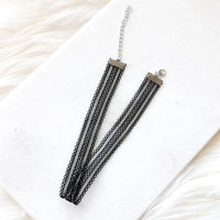 Black lace choker on a white fabric background