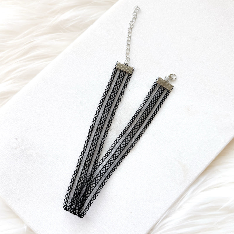 Black lace choker on a white fabric background