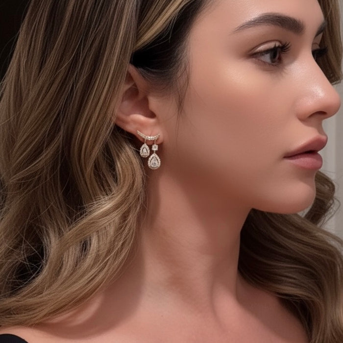 Close-up of a woman wearing diamond earrings with a neutral background