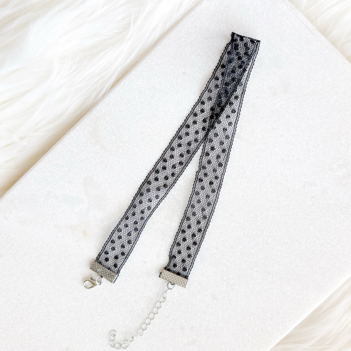 Black polka dot lace trim on a white background