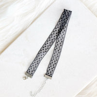 Black polka dot lace trim on a white background