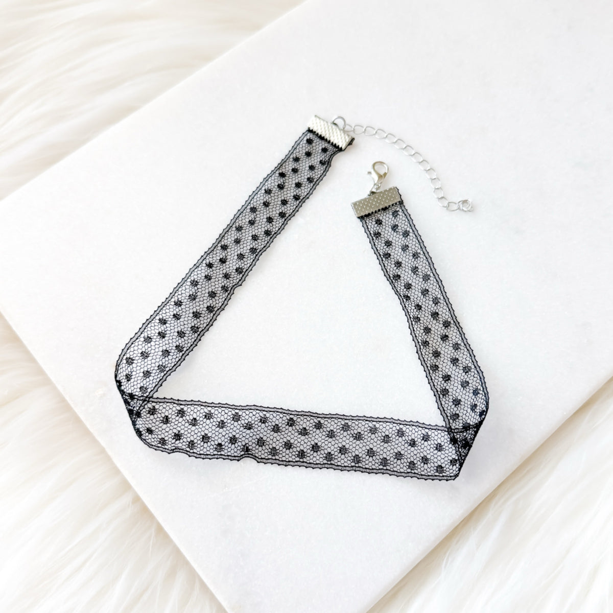 Black and white polka dot choker necklace on a white surface