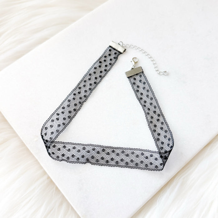 Black and white polka dot choker necklace on a white surface