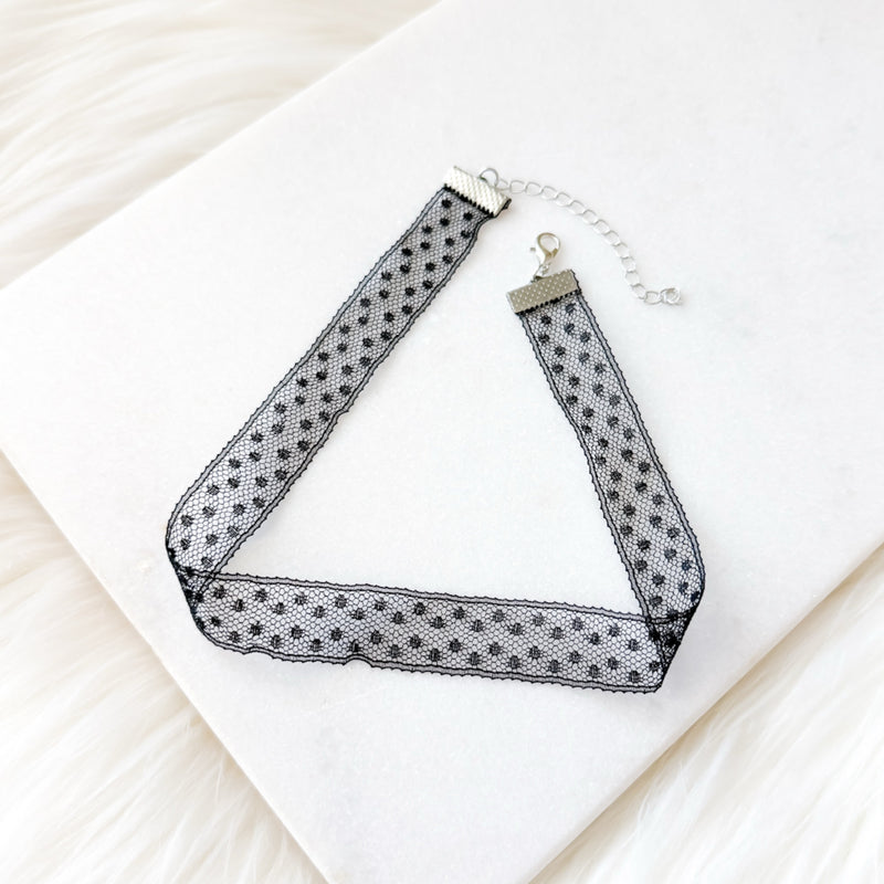 Black and white polka dot choker necklace on a white surface