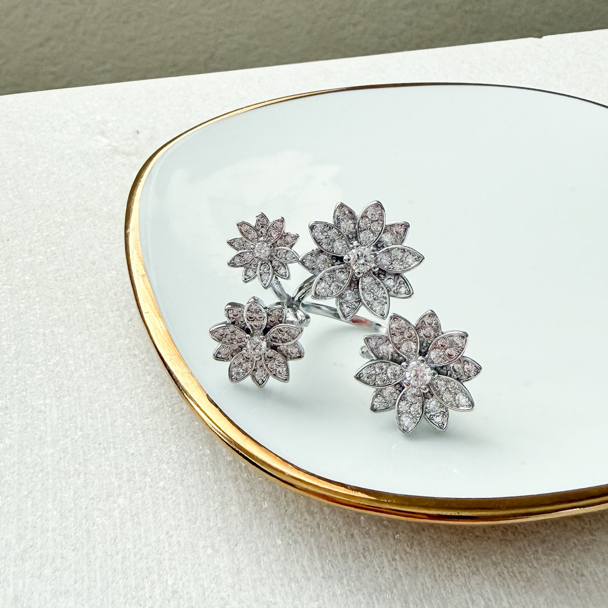 Flower-shaped earrings on a white dish with gold rim - Enchanted Garden Between the Finger Ring - The Songbird Collection
