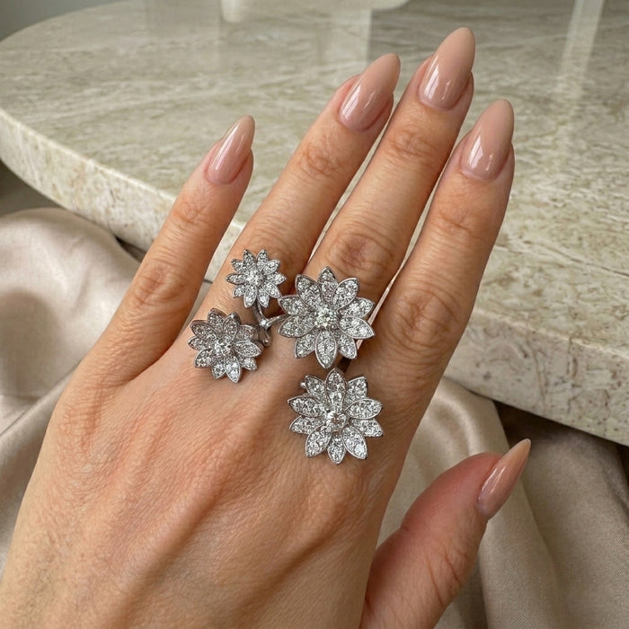 Hand wearing wrap around between the finger flower rings on a neutral background