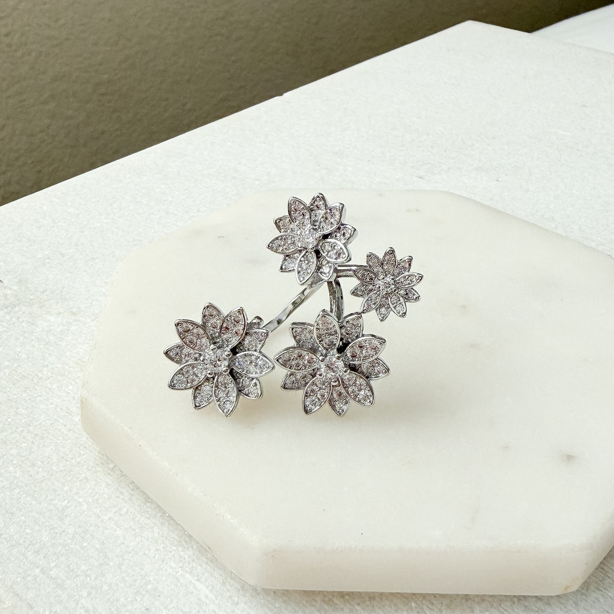 Silver floral earrings on a white stone surface - Enchanted Garden Between the Finger Ring - The Songbird Collection