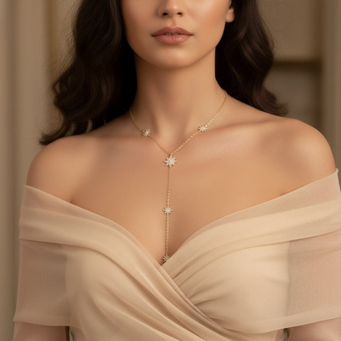 Woman wearing a delicate necklace with star-shaped pendants against a neutral background - Eternal Stars Lariat Necklace - The Songbird Collection